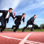 Businessmen running on track