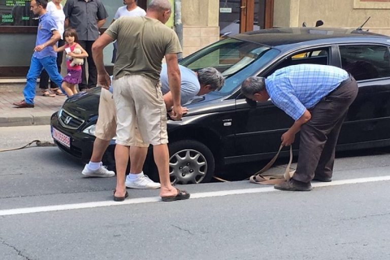 Mașină captivă în groapă, după ce asfaltul a cedat! S-a întâmplat pe o arteră circulată dintr-un oraș bănățean