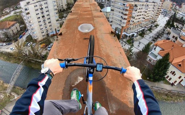 Curaj… nebun! Cu bicicleta, la zeci de metri deasupra Reșiței, pe funicular! VIDEO