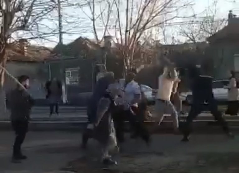VIDEO. Polițiști prinși într-o răfuială cu pari și topoare! Un agent folosește spray lacrimogen și e lovit