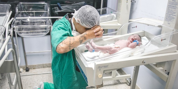 Emoţionant! Imaginea unui tată care se roagă pentru fiul său nou-născut