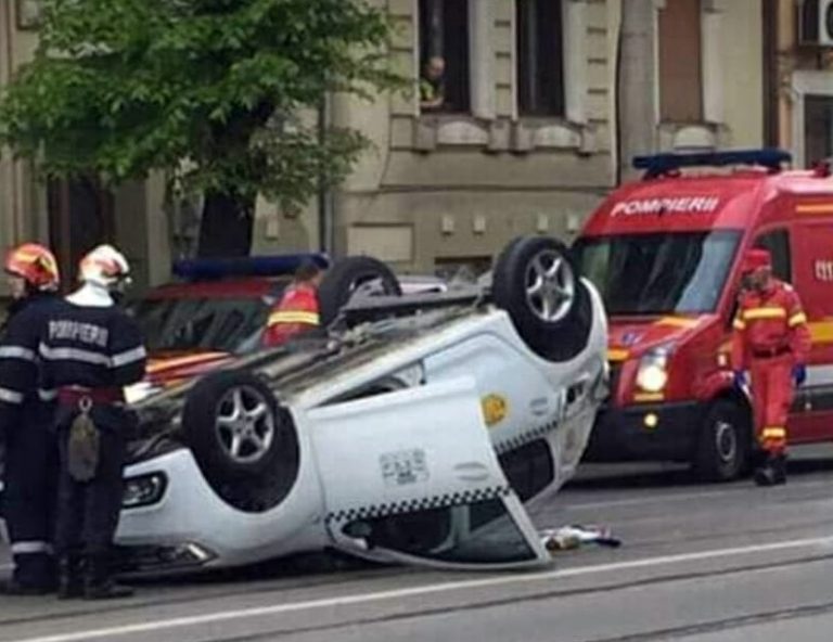 Taxi cu roțile în sus, după un accident! Șoferul și o pasageră au ajuns la spital