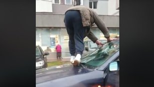 Bărbat surprins în timp ce escaladează propria maşină, pentru a ocoli bălţile formate după ploaie / VIDEO