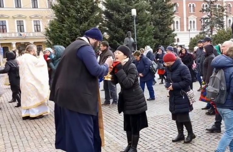 În plină pandemie: mai mulți credincioși, împărtășiți cu aceeași linguriță în timpul unei slujbe ținute afară, în fața Catedralei Ortodoxe VIDEO