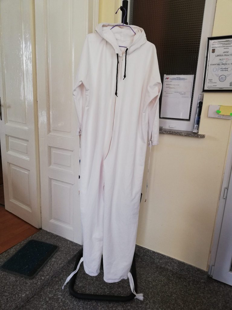 O asistentă medicală croiește echipamente de protecție